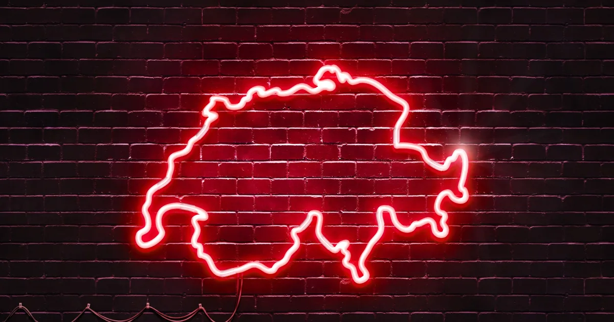 Rotes Neonschild in Form einer Landkarte leuchtet an einer dunklen Wand